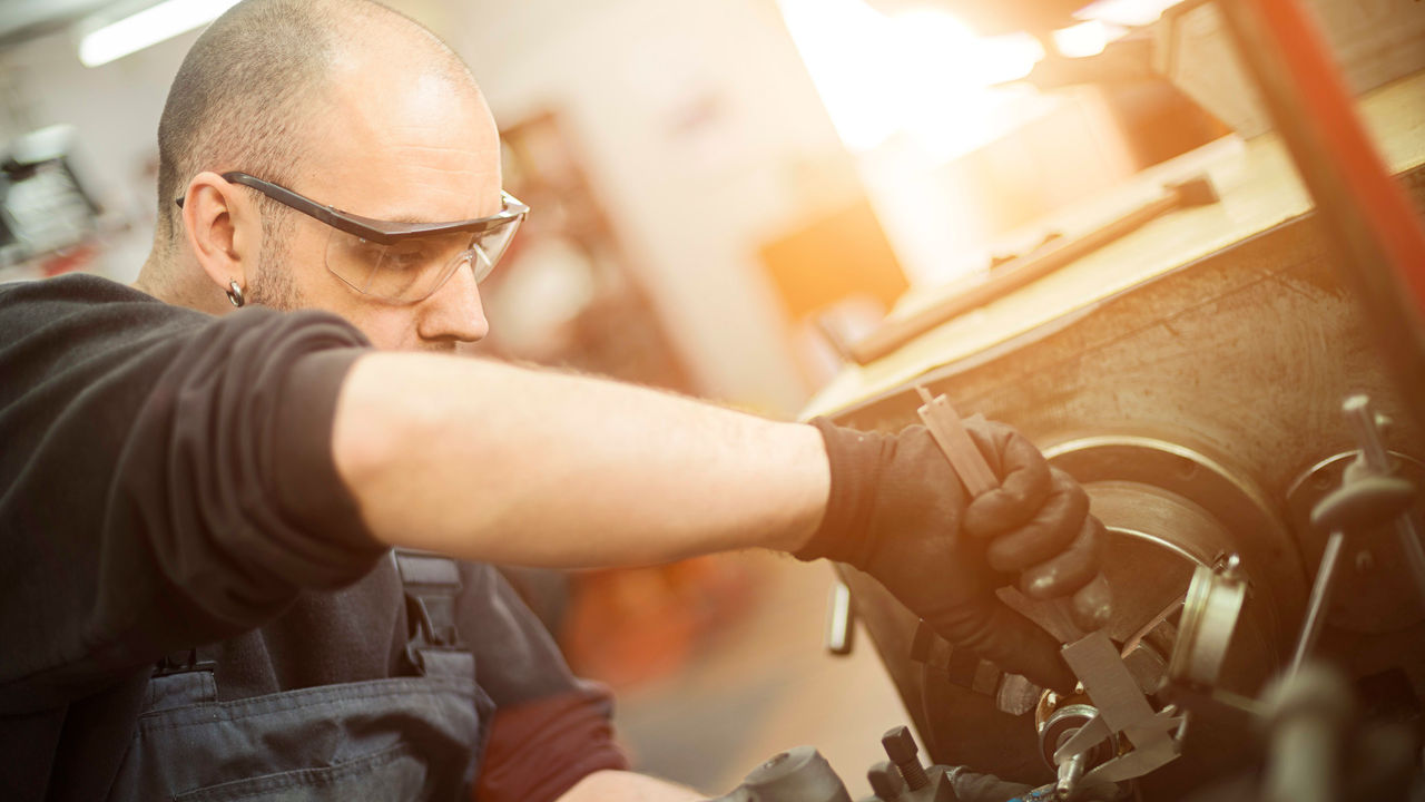 A mechanic working on a machine in a workshop.