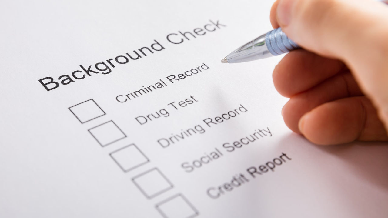 A person filling out a background check form.
