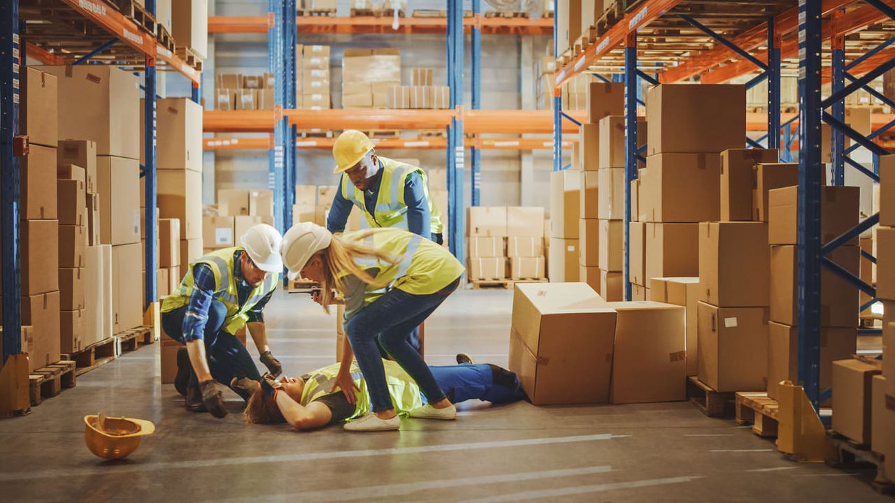 A group of workers in a warehouse laying on the floor.