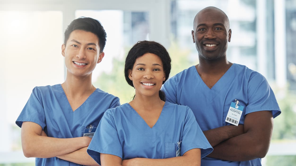 Three nurses in scrubs posing for a photo.