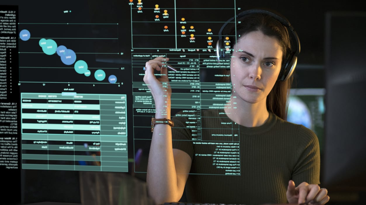 A woman is working on a computer with a map on the screen.