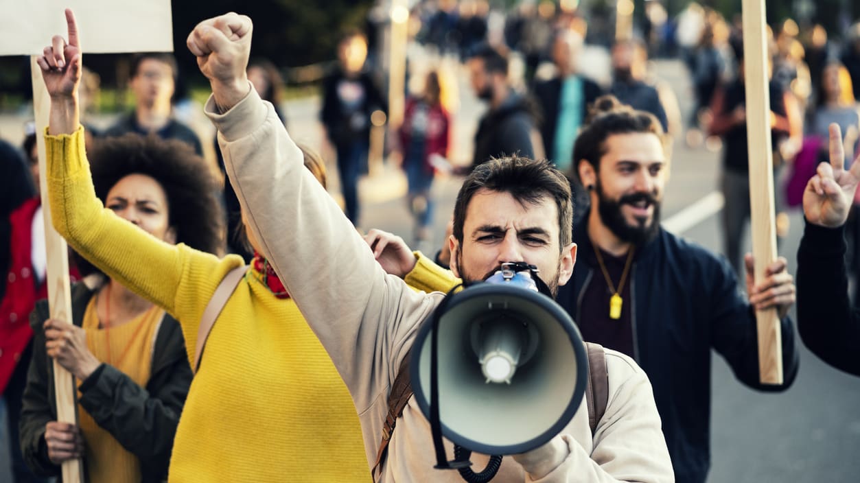 A group of people holding signs and a megaphone.