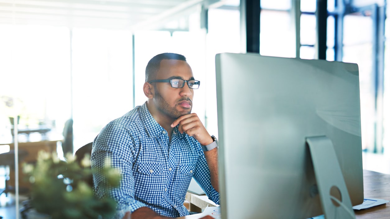 A man sitting at a desk in front of a computer.