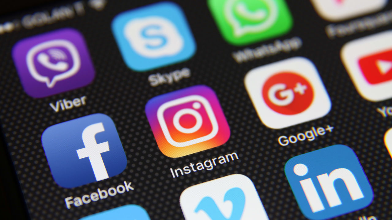 Social media icons are displayed on a cell phone.