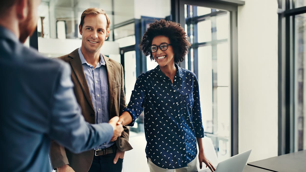 Two business people shaking hands in an office.