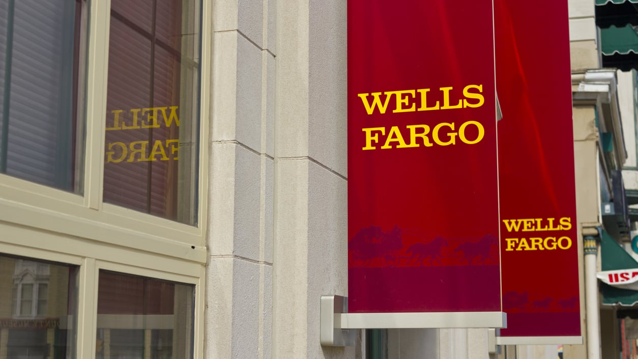 A wells fargo sign hangs on the side of a building.