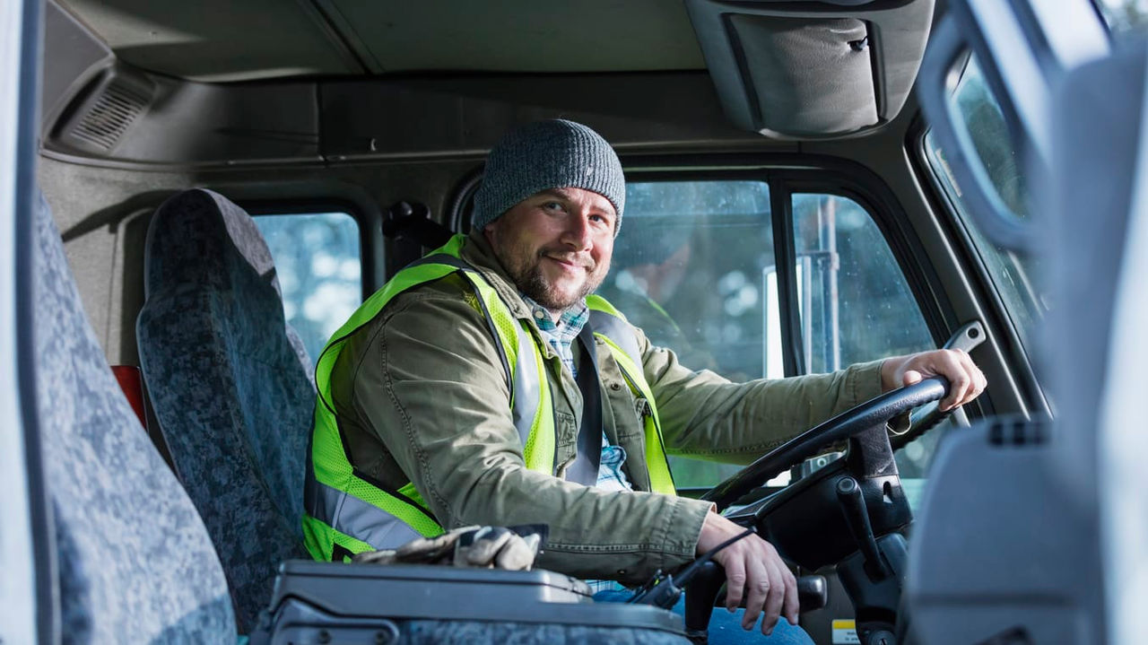 A man sitting in the driver's seat of a truck.