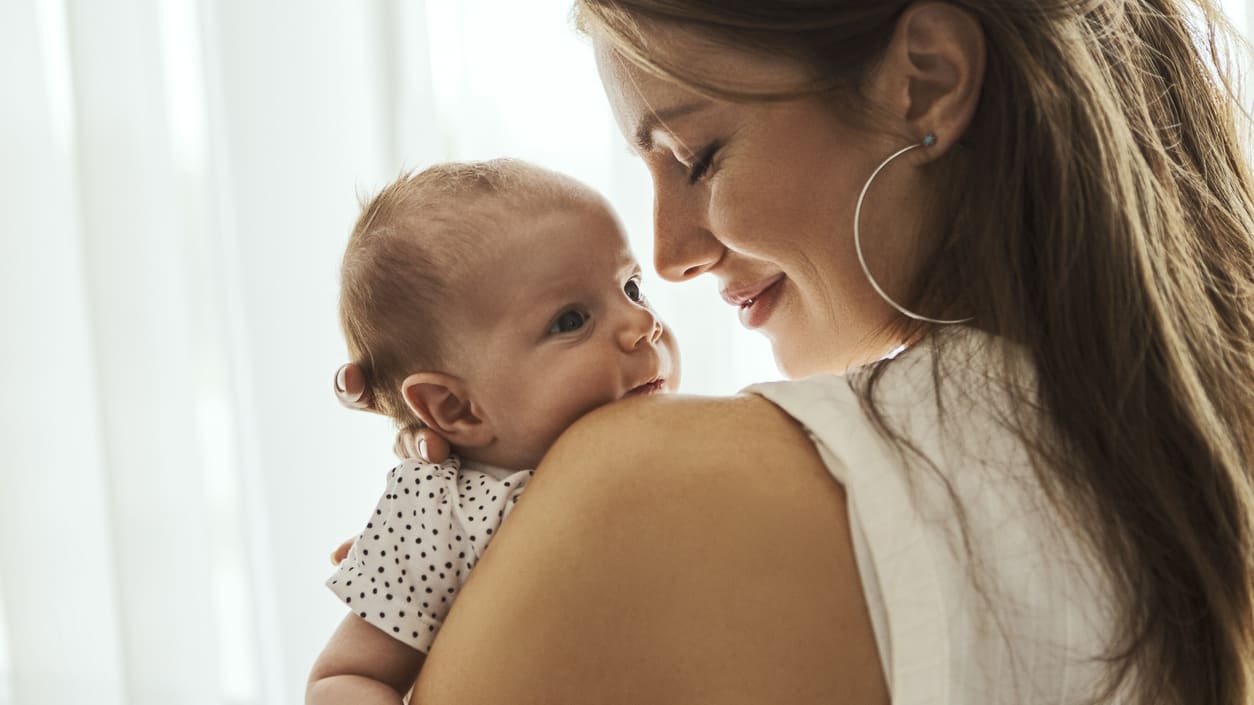 A woman is holding her baby in her arms.