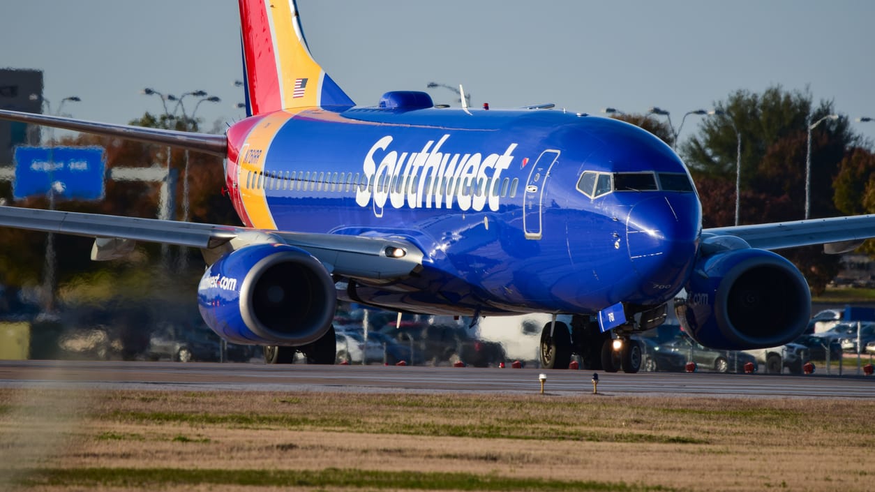 A southwest airplane is taking off from an airport.