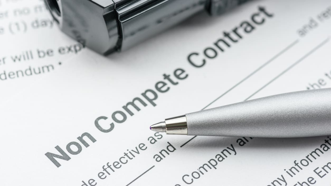 A pen sits on top of a non compete contract.