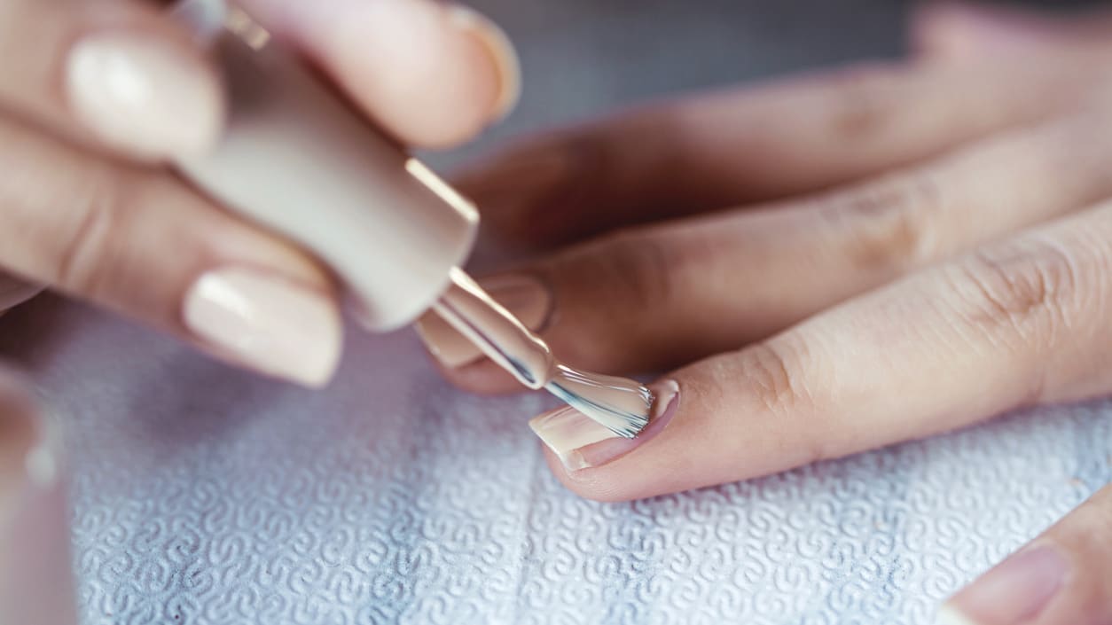 A woman is getting her nails done by a manicurist.
