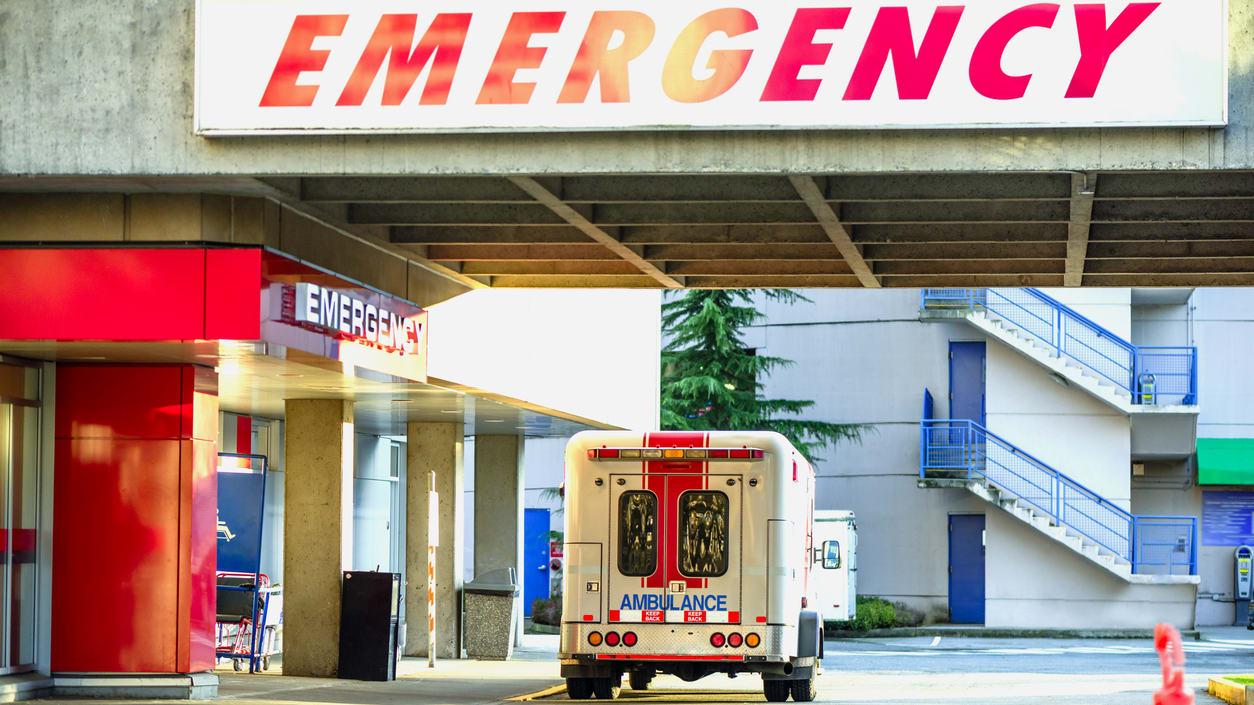 An ambulance parked in front of an emergency entrance.