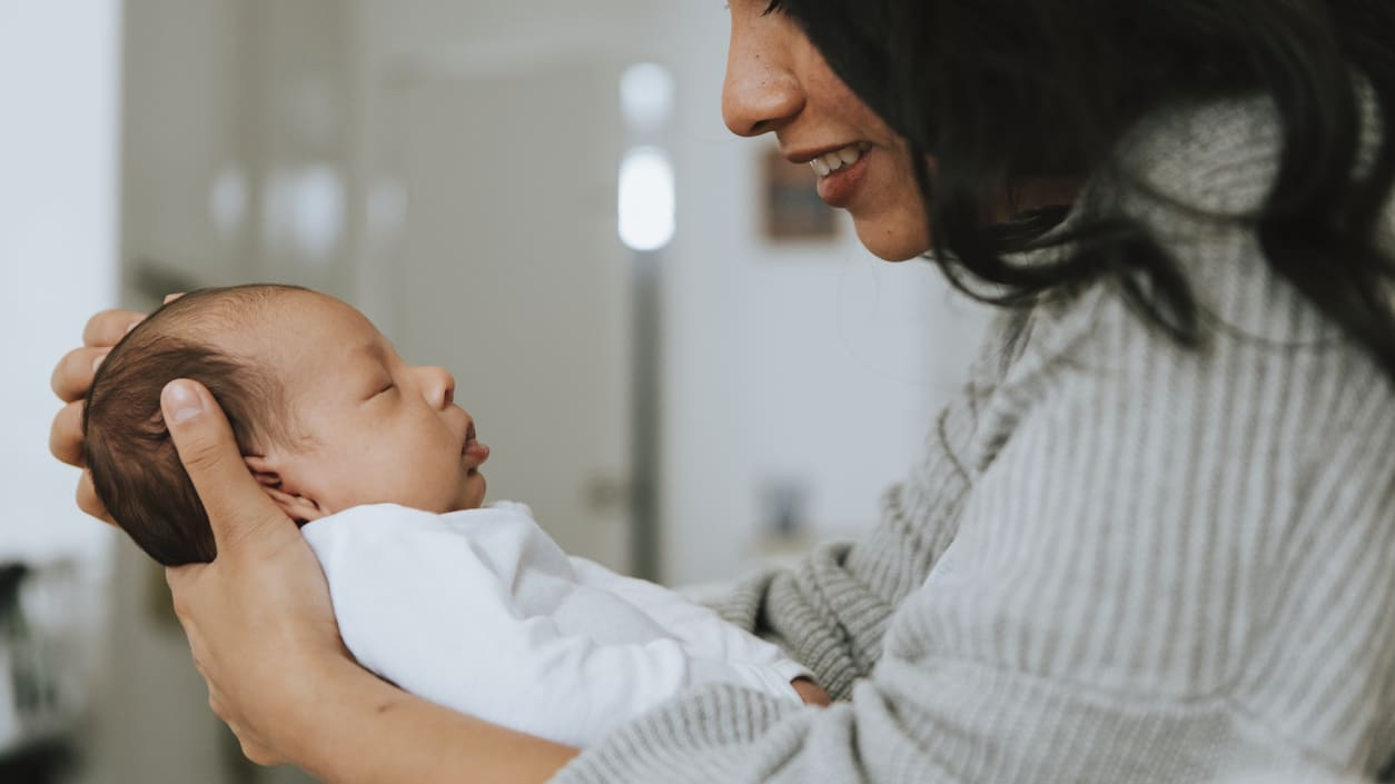 A woman is holding a baby in her arms.