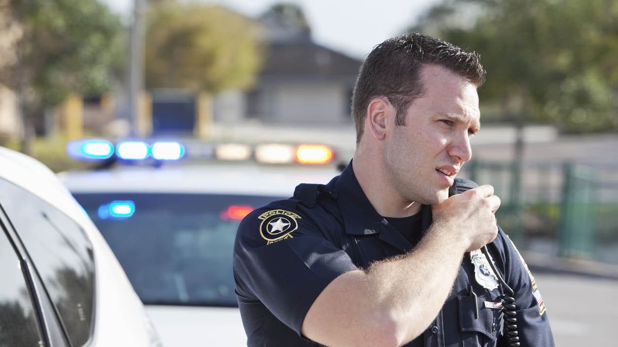 A police officer talking on his cell phone.