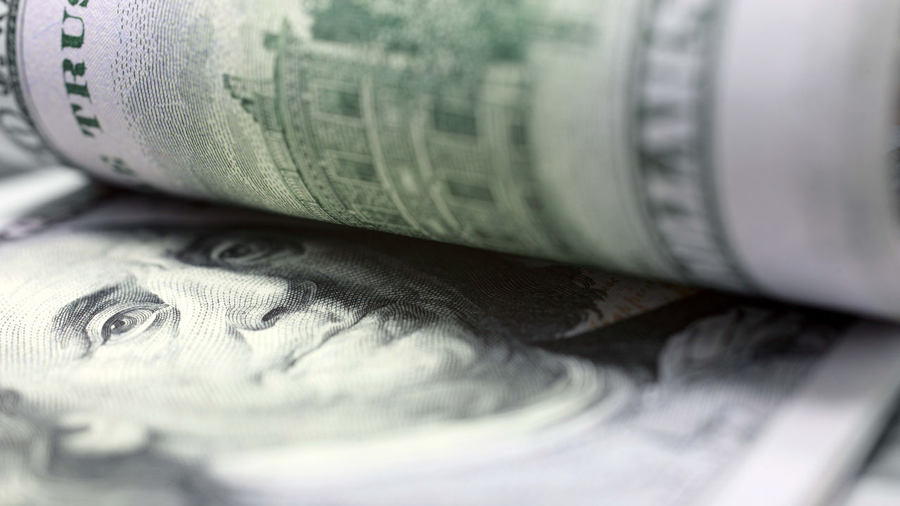 A stack of us dollar bills on a table.