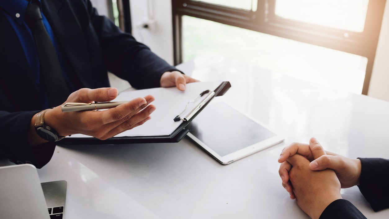 Two business people sitting at a table and talking to each other.