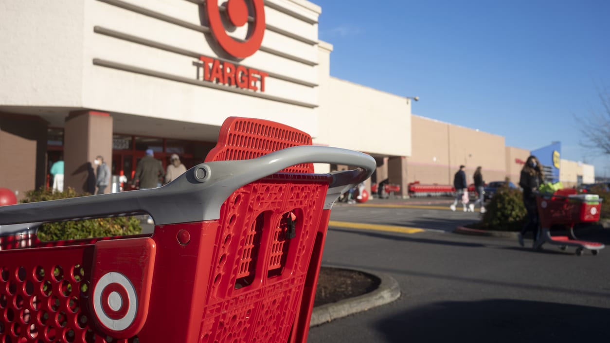 A red shopping cart is parked in front of a target store.