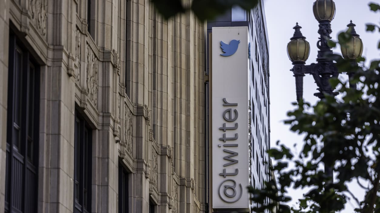 The twitter logo is seen on the side of a building.