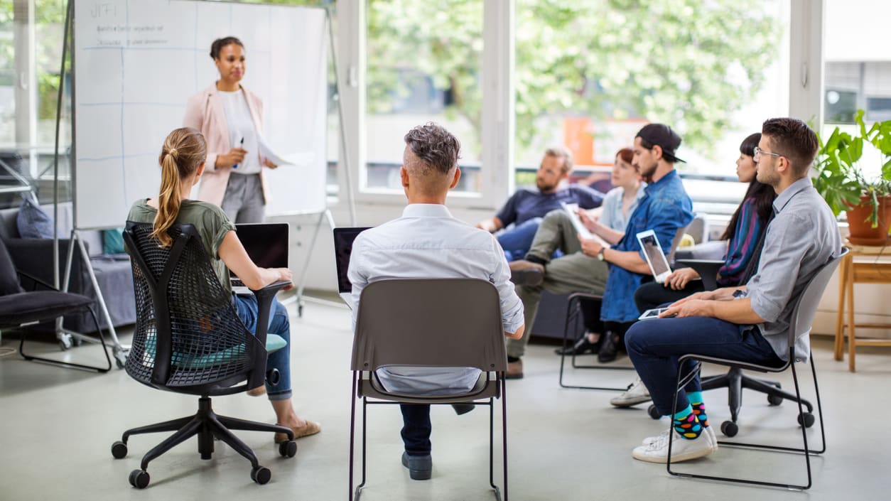 A group of people sitting in chairs in a meeting room.