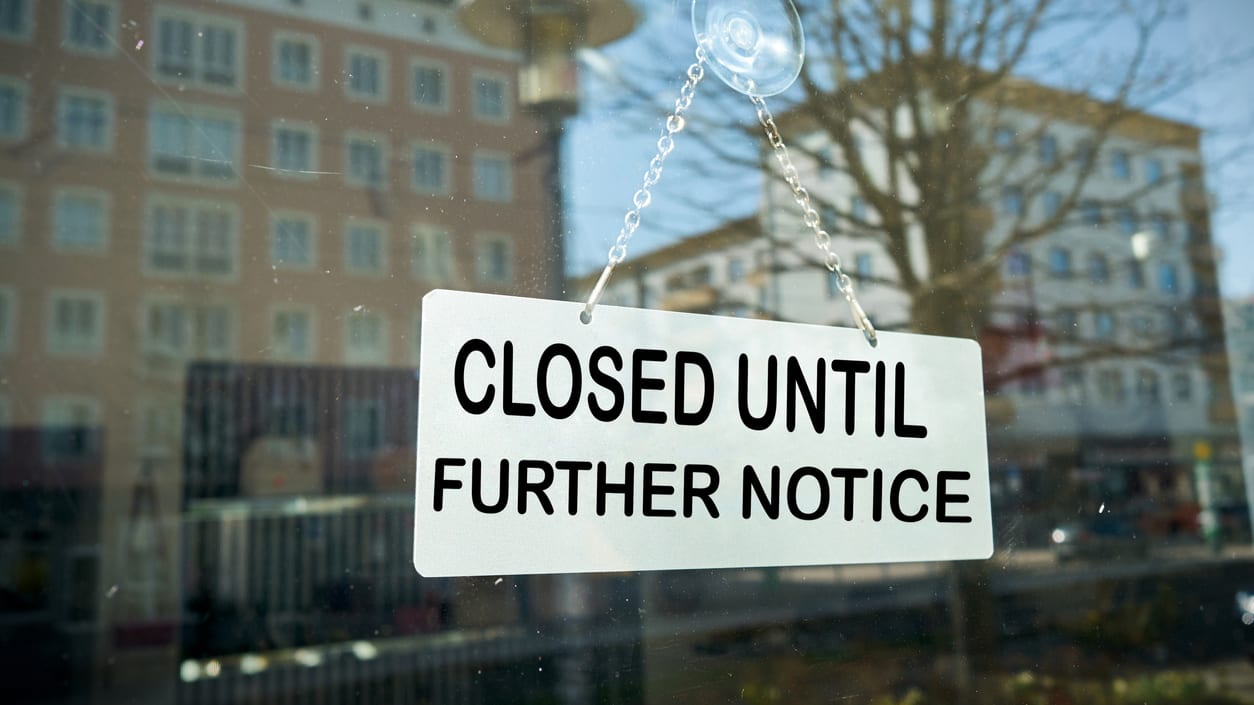 A closed until further notice sign hangs from a window.