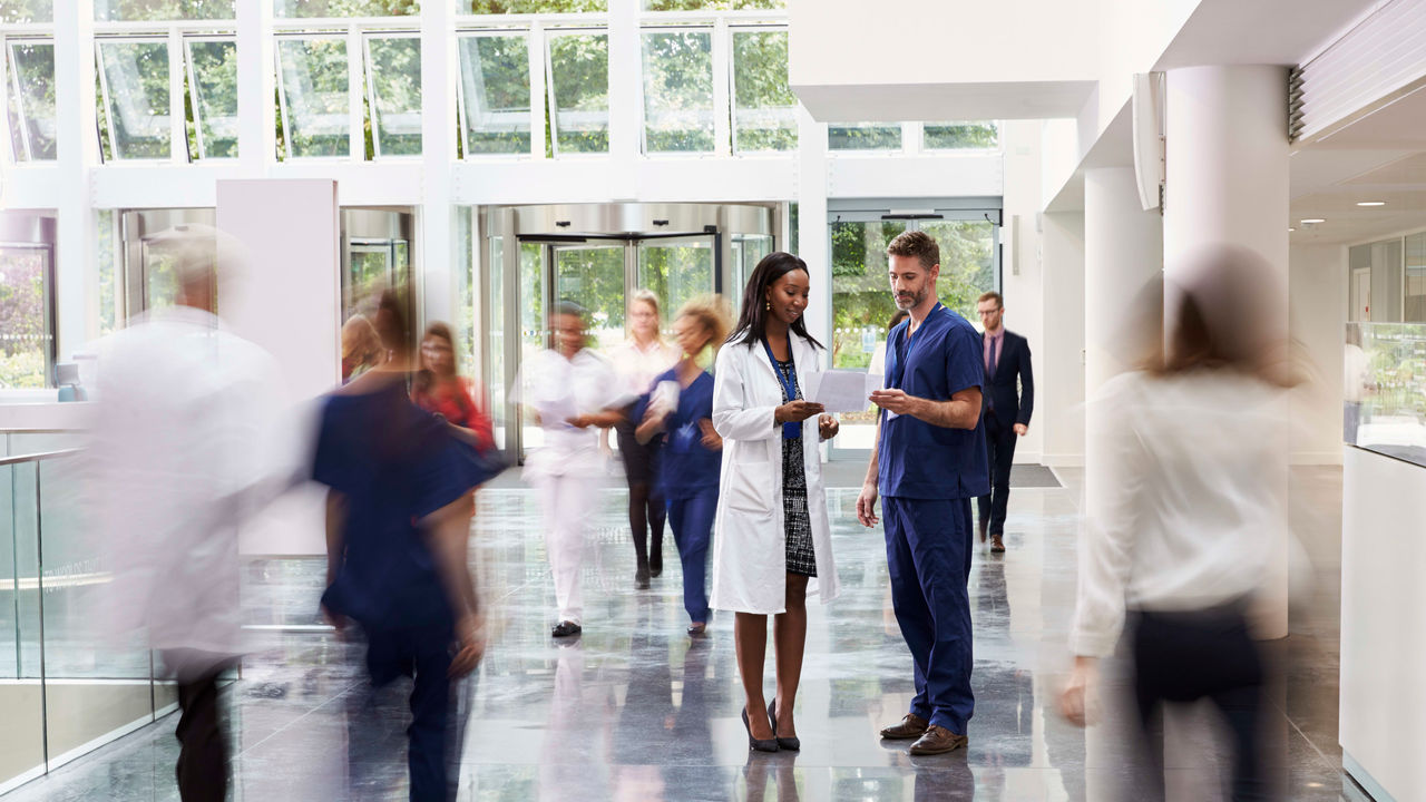 A group of people walking through a hospital hallway.
