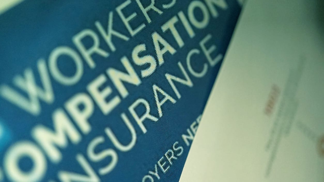 A worker's compensation insurance brochure is on a table.