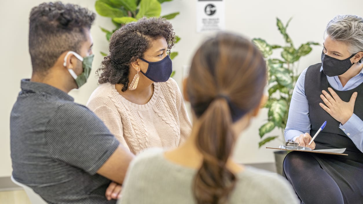 A group of people wearing face masks in a waiting room.