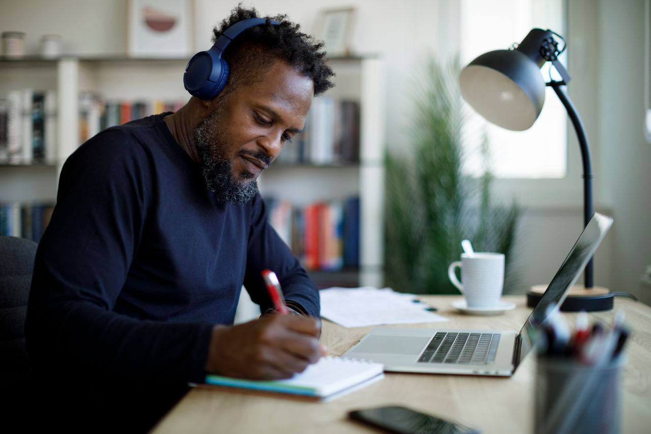 Man with bluetooth headphones working at a home office.