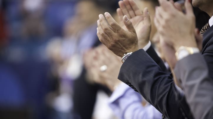 A group of people clapping at an event.