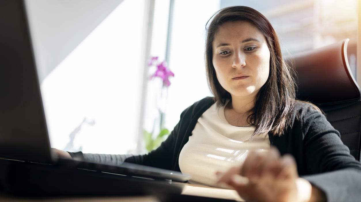 A woman sitting at a desk with a laptop.