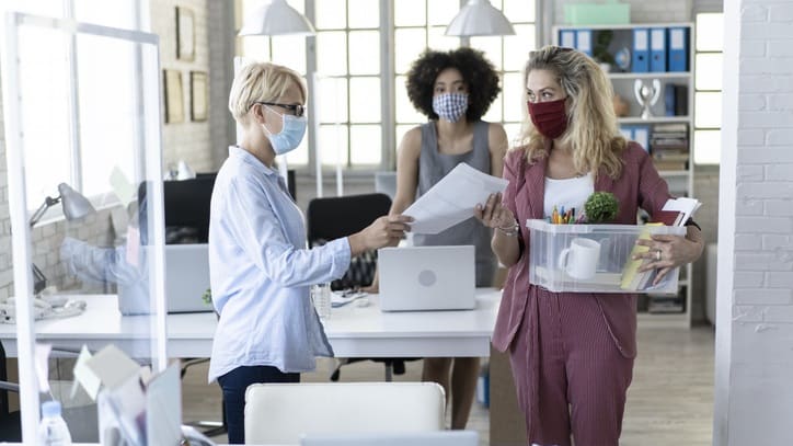 Two women wearing face masks in an office.