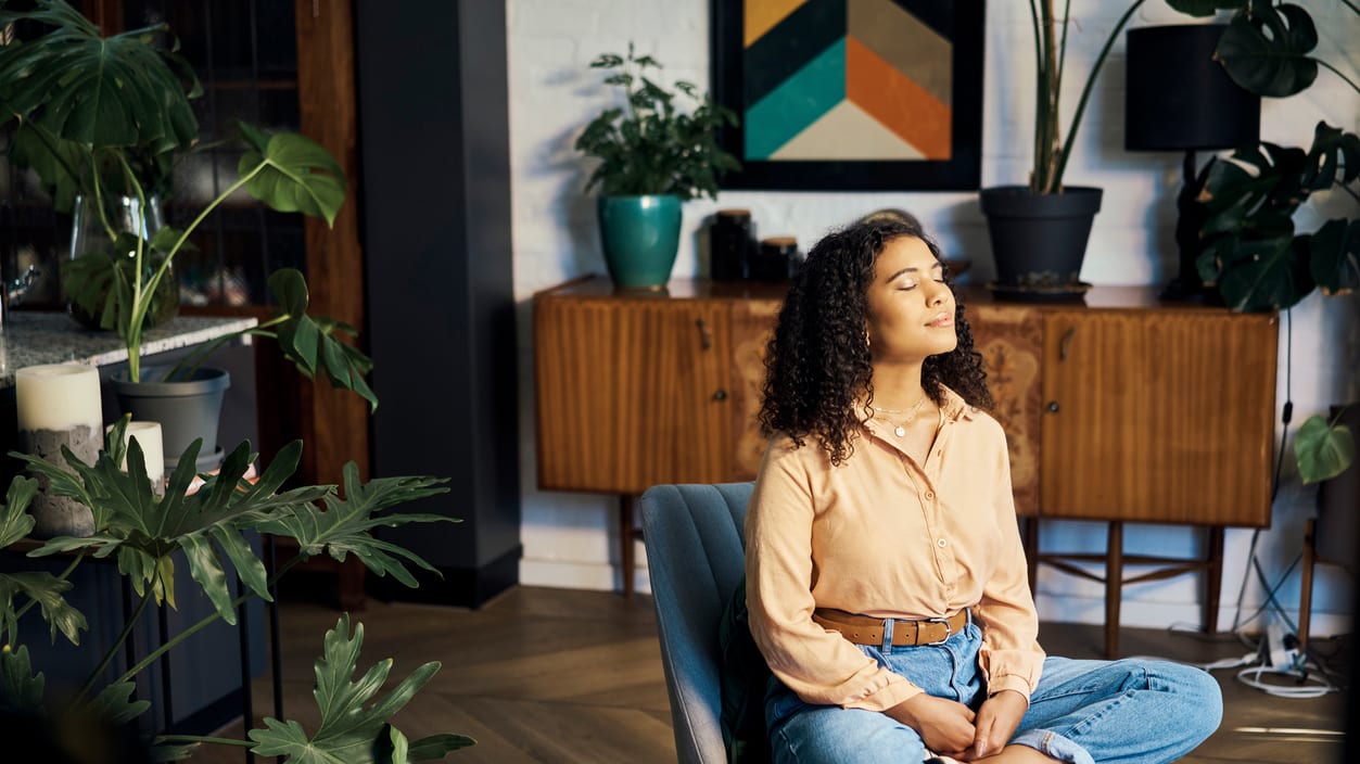 A woman sitting in a chair and meditating.