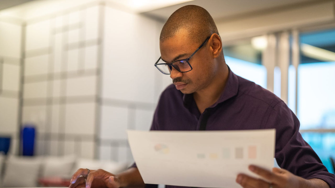 A businessman is looking at a document on his phone.