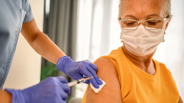 A woman is getting a vaccine in her arm.