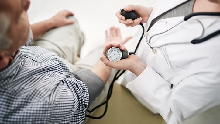 A doctor is checking a patient's blood pressure.