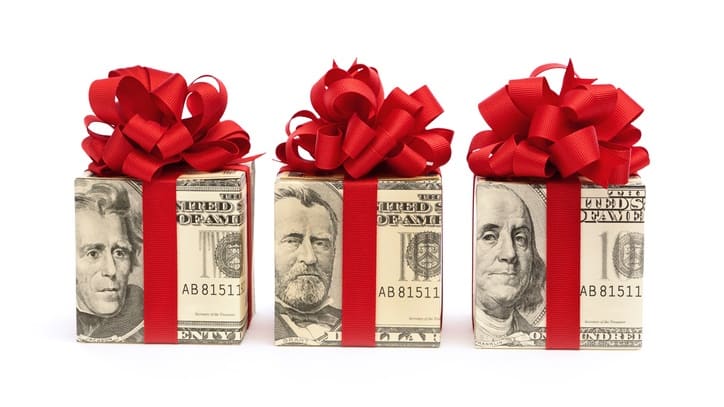 Three gift boxes with dollar bills tied with red ribbons.