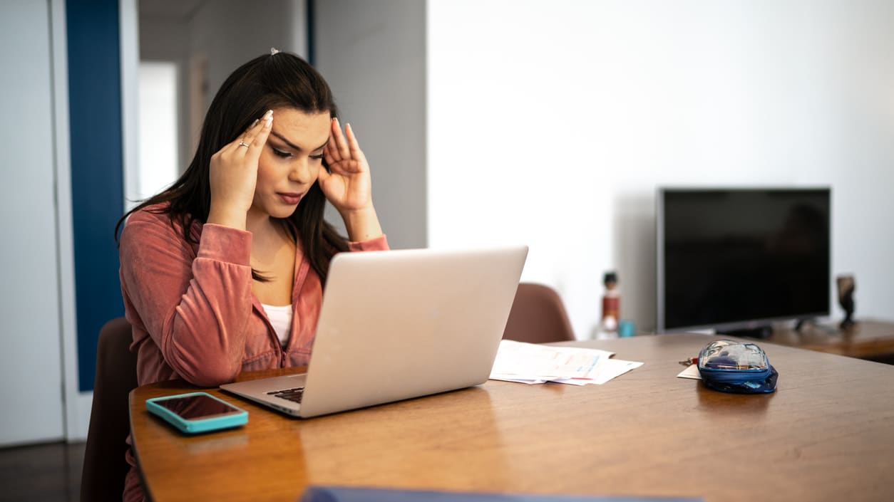 A woman is sitting at a table with a laptop.