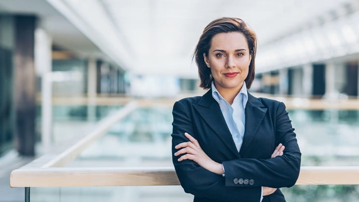 A business woman in a suit standing in an office.