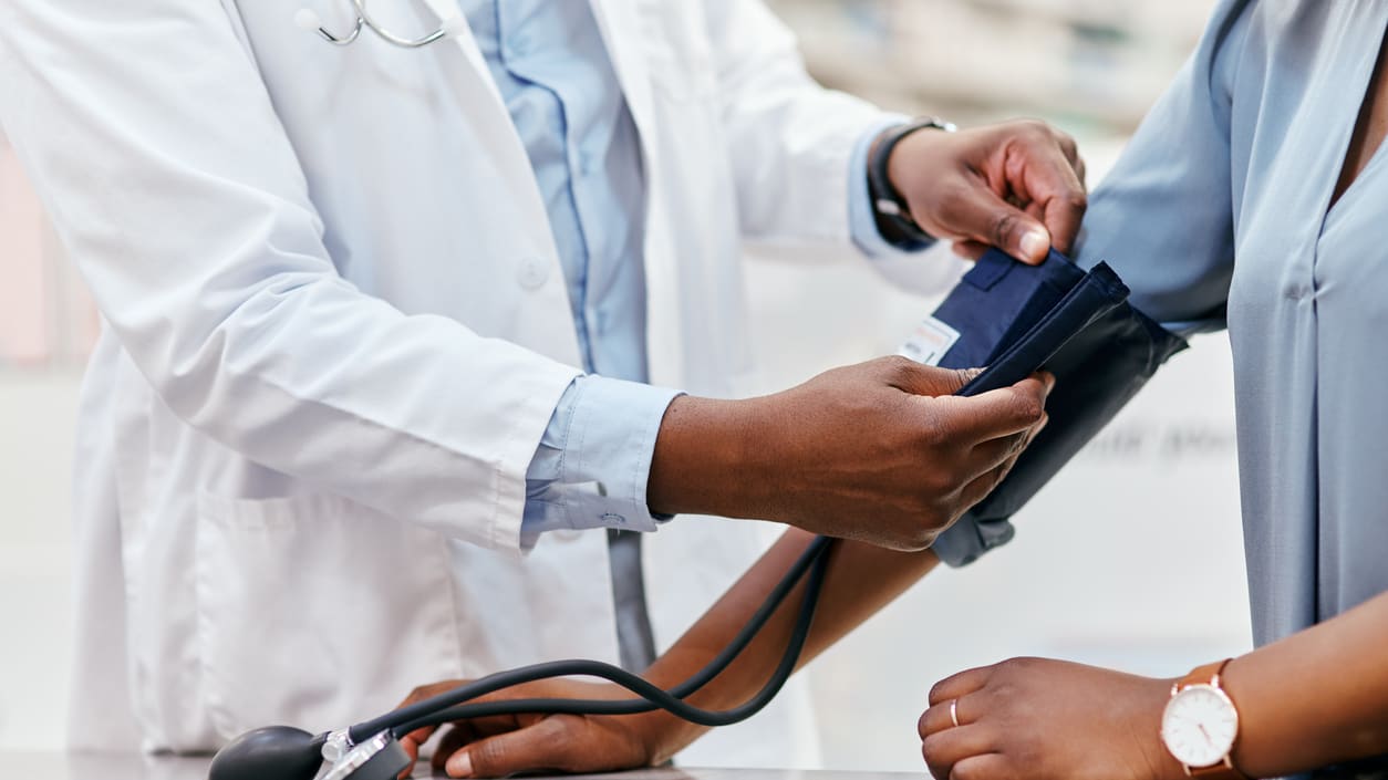 A doctor is checking a woman's blood pressure.