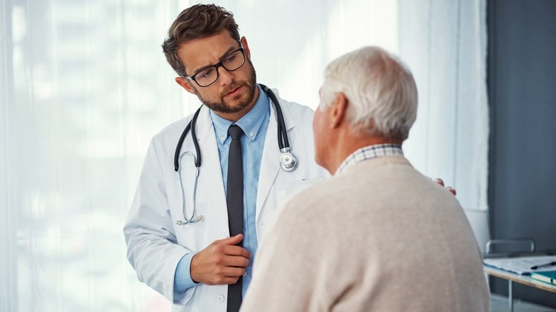 A doctor is talking to an elderly man.