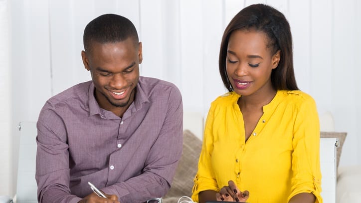 A man and woman working on their finances at home.