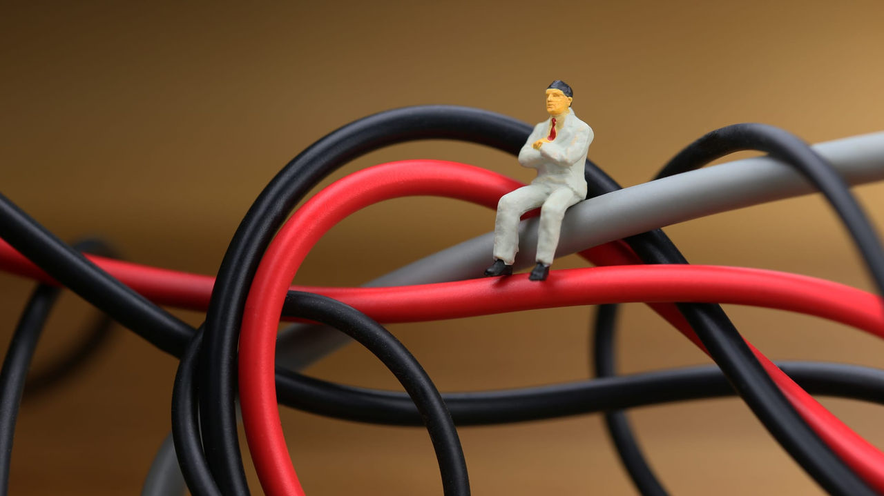 A miniature man sitting on top of a bunch of wires.