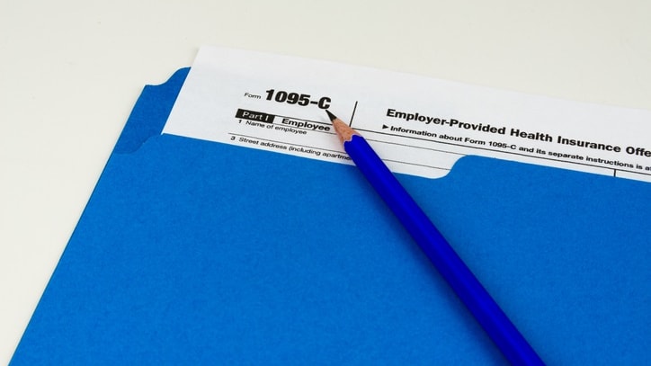 A blue pencil sits on top of a blue tax form.