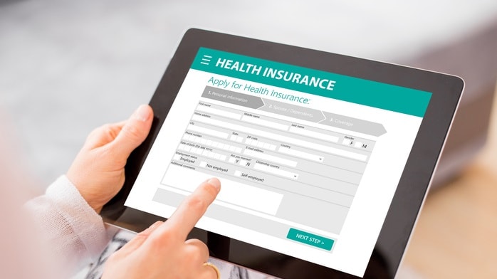 A woman pointing at a health insurance application on a tablet.