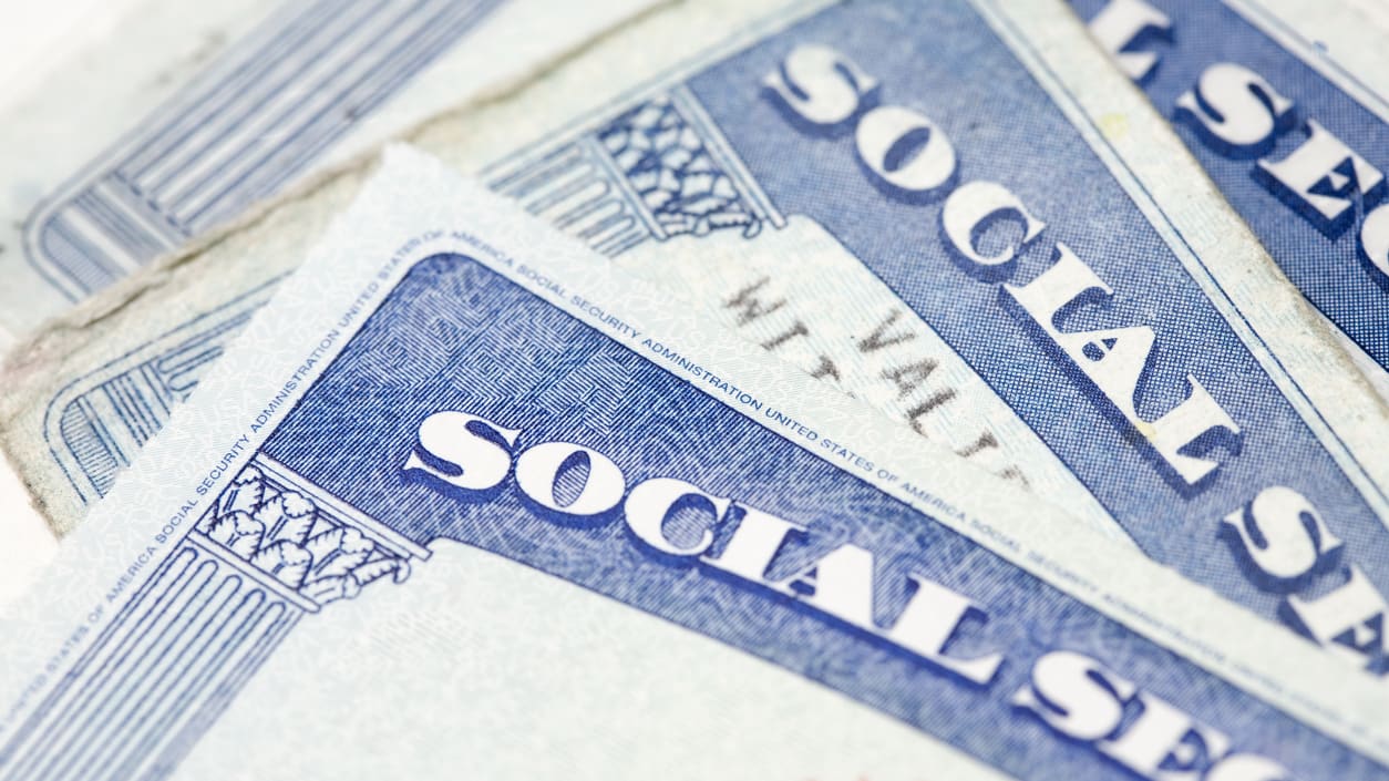 A stack of social security cards on a white background.