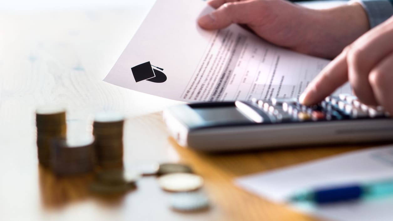 A man is holding a calculator and a piece of paper.