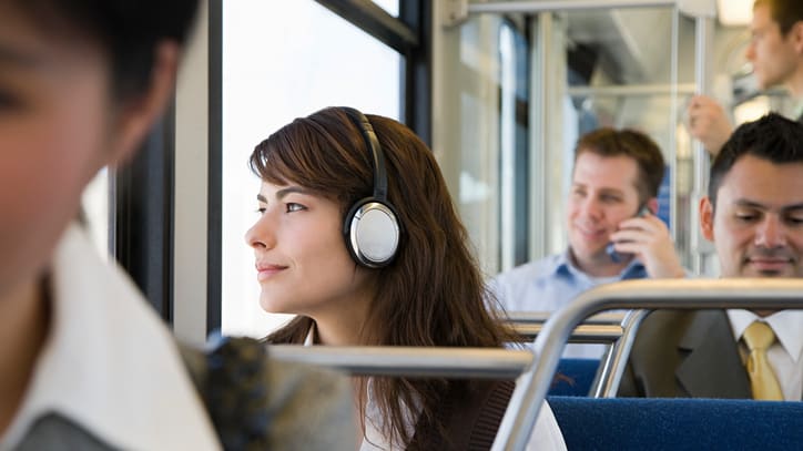A group of people on a bus with headphones on.