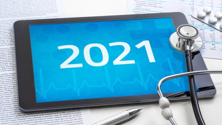 A tablet with the word 2021 on it next to a stethoscope.