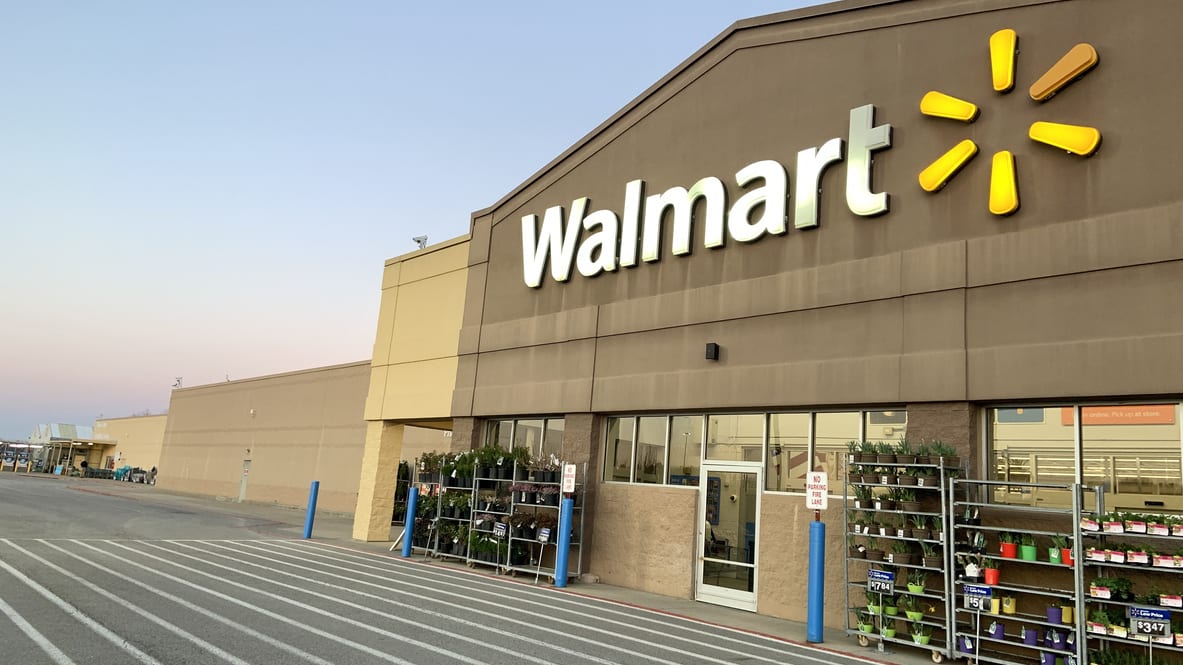 A walmart store in a parking lot at dusk.