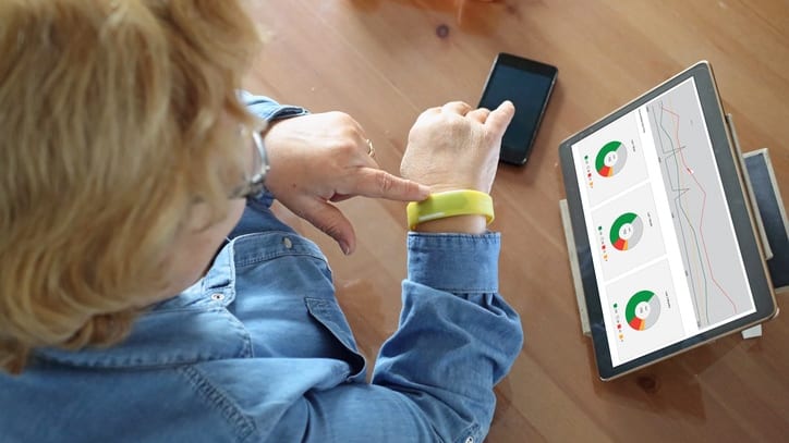 A woman is using a tablet to check her blood pressure.